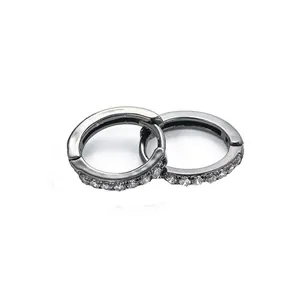 Macro detail of black hoop earrings with clear cubic zirconia micro-pave setting