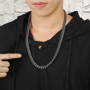 Men's vintage black stainless steel Cuban curb chain necklace on model with brick background