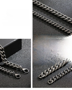 Macro detail of dark grey brushed stainless steel Cuban link chain with lobster clasp