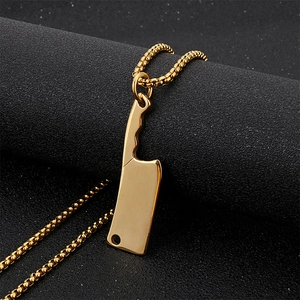 Macro view of a gold-plated stainless steel mini cleaver pendant on a box chain necklace