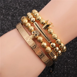 Men's gold bracelet set featuring Roman numeral cuff, crown, and skull charm beads