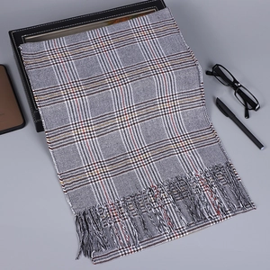 Vue détaillée d'une écharpe à carreaux gris avec franges et accessoires de bureau