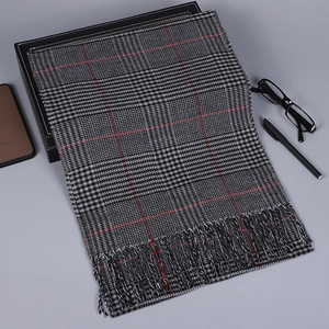 Détail de la texture d'écharpe à carreaux rouge et gris avec franges naturelles douces