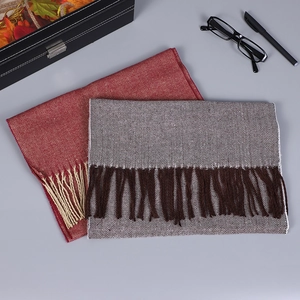 Détail du tissage à chevrons et franges douces sur écharpes d'hiver bordeaux et taupe