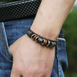 Close-up of handmade multilayer leather bracelet with dark brown beads and vintage metal rings