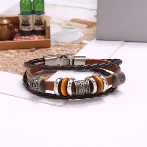 Detail of multi-layer brown braided leather bracelet with silver metal and wooden beads
