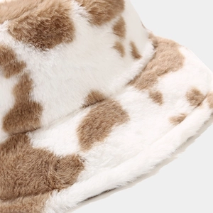 Detailed close-up of soft cow print faux fur texture on a thick winter bucket hat