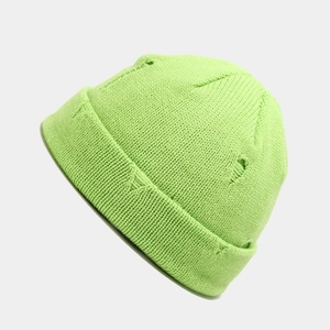 Close-up of fluorescent green distressed knit beanie with detailed torn texture and ribbing