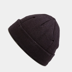 Close-up of dark distressed knit beanie showing ripped texture and vertical ribbing