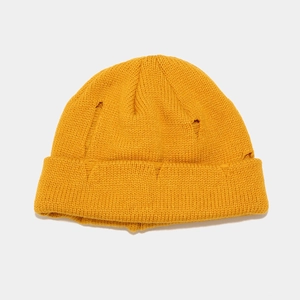 Detailed knit texture of mustard yellow distressed beanie with ripped street style design