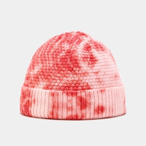 Close-up of pink and red tie-dye knit beanie showing detailed coarse texture and pattern