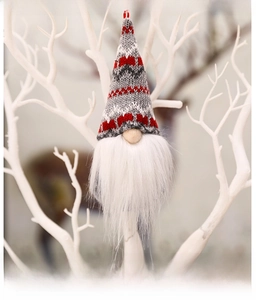 Close-up of knitted Christmas gnome ornaments with white faux fur beards and hanging strings