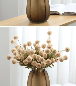 Modern faux dandelion bouquet in a ribbed amber glass vase for home table decor