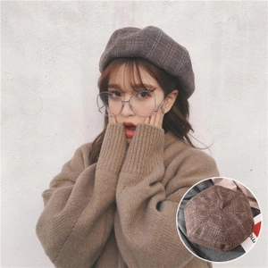 Close-up of brown grey checkered beret hat fabric texture and winter style outfit