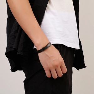 Minimalist black braided leather bracelet with stainless steel bar on male wrist