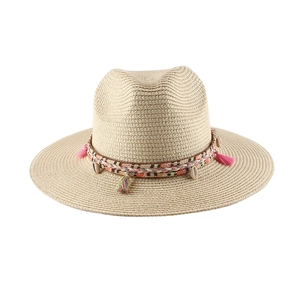 Dettaglio cappello di paglia con fascia intrecciata colorata, nappa rosa e ciondolo conchiglia