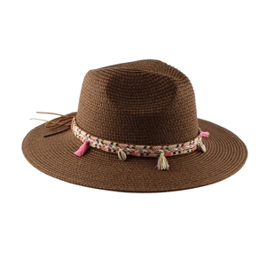 Dettaglio cappello di paglia con fascia etnica, nappe colorate e conchiglie naturali