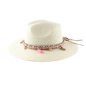Dettaglio del cappello di paglia crema con nappe colorate, conchiglie e nastri intrecciati