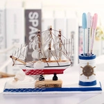 Détail d'un porte-stylo voilier méditerranéen en bois avec décor de gouvernail