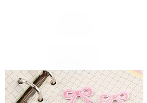 Detail showing pink embroidered bow patch with self-adhesive backing for clothes