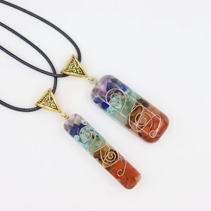Detailed close-up of 7 chakra stones pendant necklace with copper wire wrapping