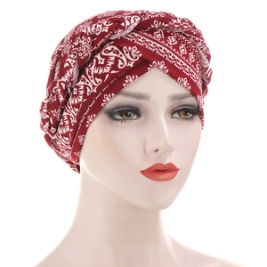 Macro detail of red paisley turban hat featuring braided knot design on a mannequin