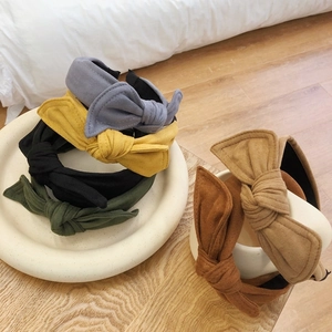 Set of six colorful velvet bow headbands displayed in a cozy lifestyle setting