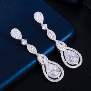 Macro shot of silver-colored teardrop earrings encrusted with AAA cubic zirconia stones