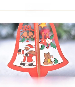 Detail of laser-cut wooden Christmas bell ornament with painted Santa and bear elements