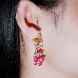 Elegant rose gold butterfly drop earrings with gradient zircons worn by a model