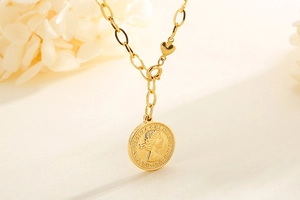 Macro shot of gold coin pendant with Elizabeth II engraving on stainless steel chain