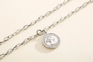 Macro view of silver coin pendant necklace showing Queen portrait on chunky chain link