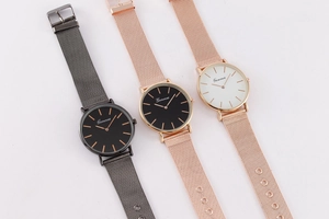 Close-up of minimalist quartz watches with Milanese mesh bands in grey and rose gold