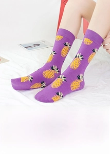 Detailansicht lila Socken mit gelbem Ananasmuster, von einem Model getragen