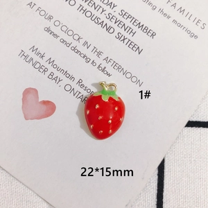 Macro detail of red strawberry pendant with size label on a decorative white card