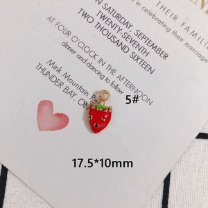 Detail view of 17.5x10mm red strawberry enamel charm with green leaf accents