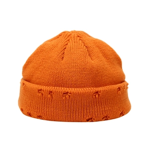 Distressed bright orange knit beanie hat with a vintage street style for winter warmth