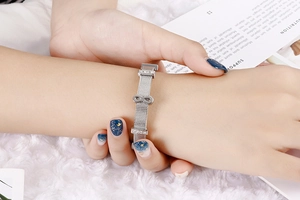 Close-up of silver mesh bracelet with infinity symbol and crystals on a model wrist