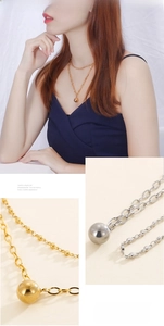 Detail of minimalist double-layer chain necklace featuring mirror polished ball pendants