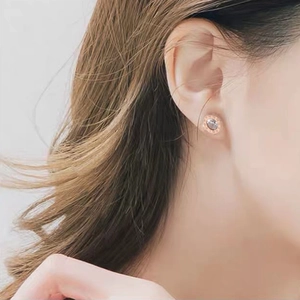Rose gold Roman numeral stud earrings with crystal center on a female model