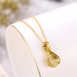 Macro shot of 18K gold violin pendant with hollow design and inlaid zircon stones