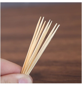 Close-up of hand holding a bunch of premium thin bamboo toothpicks for household use