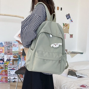 Vista laterale dello zaino in nylon verde chiaro con ciondolo a forma di cagnolino