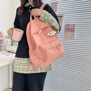 Dettaglio zaino rosa in nylon impermeabile con un simpatico ciondolo a forma di cucciolo