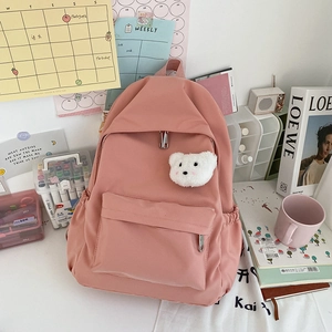 Dettaglio di uno zaino rosa impermeabile con un simpatico portachiavi a forma di orso