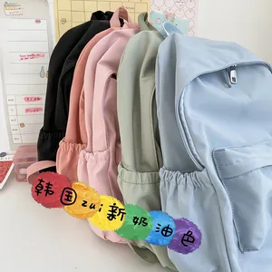 Dettaglio laterale di zaini in nylon pastello in vari colori con tasche e cerniere