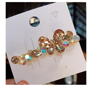 Close-up of golden butterfly hair clip with champagne K9 crystals on a display card
