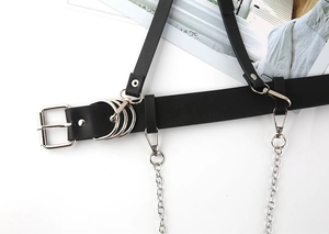 Detail of black punk style PU leather belt with silver metal buckles and chain accents