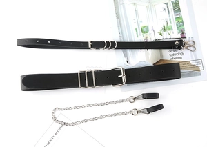 Detail of fashion black leather waist belt set with silver metal chains and thin straps