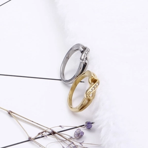 Knot design paved stone ring in gold and silver finish on white faux fur background